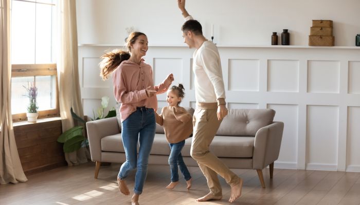 Happy Family Dancing Around Their New House - Forge Home Consulting